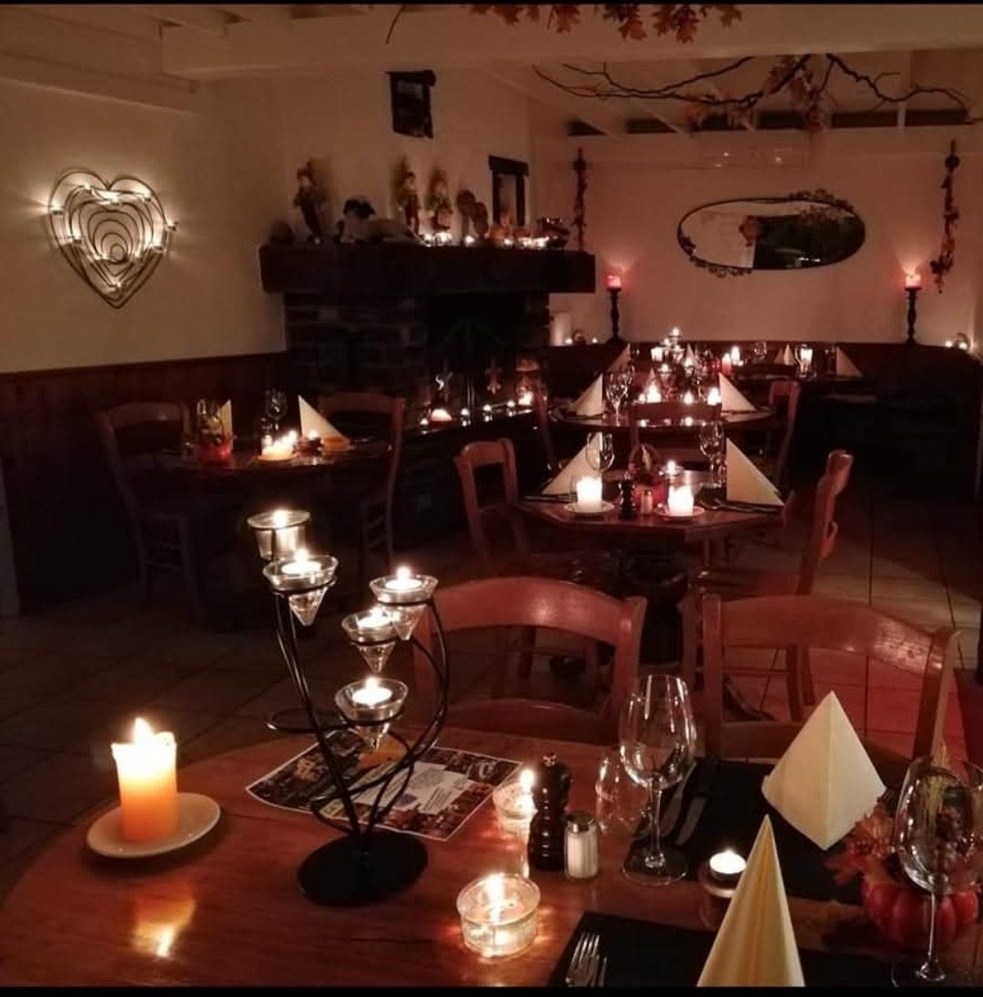 Souper aux chandelles au Bourg-Ville : tables dressées à la lueur des bougies, cheminée allumée